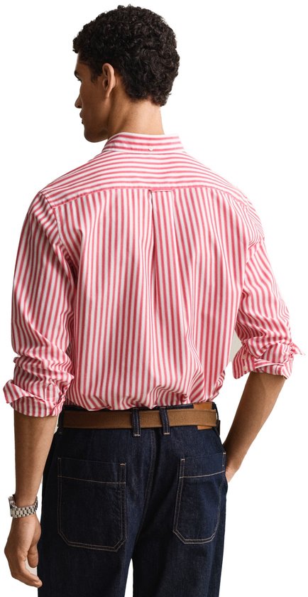 Man, achterkant, rood en wit gestreept button-down overhemd, denim jeans, bruine riem.