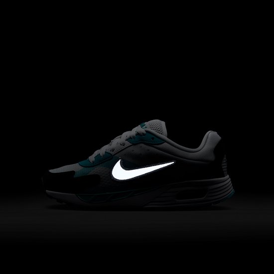Zijaanzicht in het donker met een oplichtende reflecterende swoosh op de sneaker.