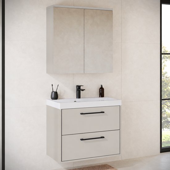 Hangend beige badkamermeubel met twee lades, zwarte handgrepen, witte wastafel en bijpassende spiegelkast.
