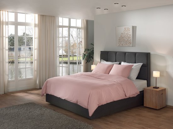 Dekbedovertrek van gewassen katoen in 'Haze Coral' roze op een donkergrijs bed in een moderne slaapkamer.