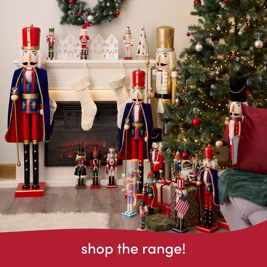 Diverse kerstnotenkrakers, groot en klein, bij een open haard, kerstboom en cadeaus.