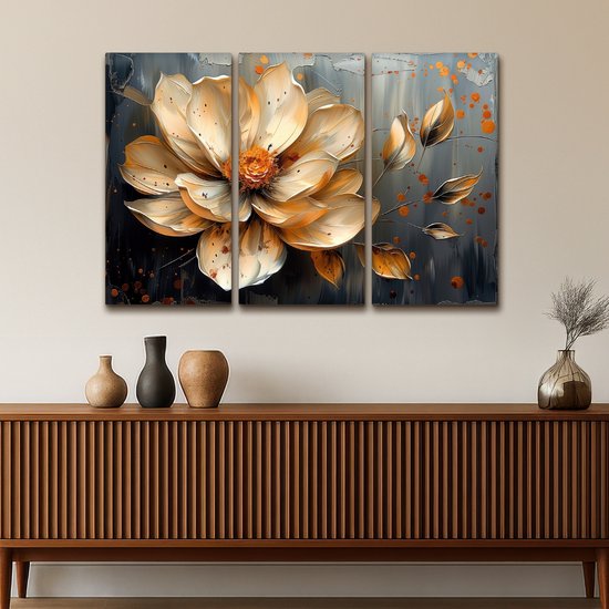 Une peinture triptyque d'une fleur abstraite dorée avec des accents orange sur un fond gris foncé, au-dessus d'un buffet.