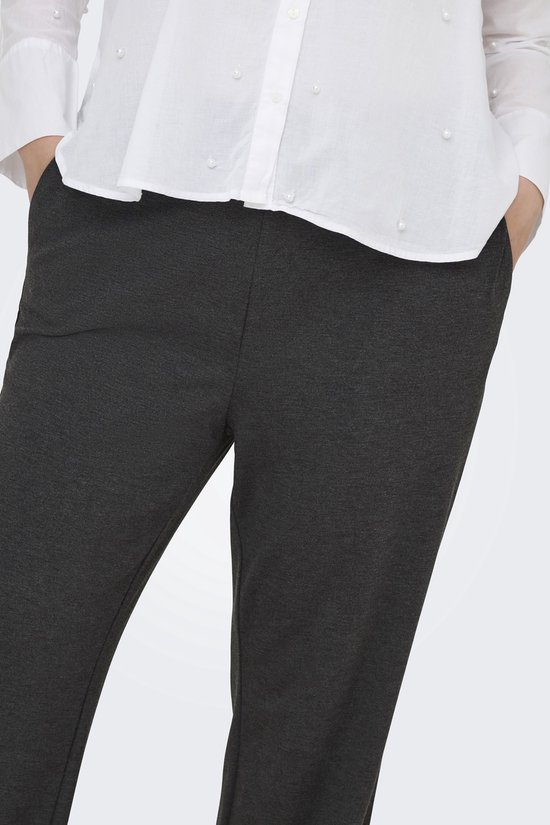 Detail van de donkergrijze wijde broek met steekzakken.