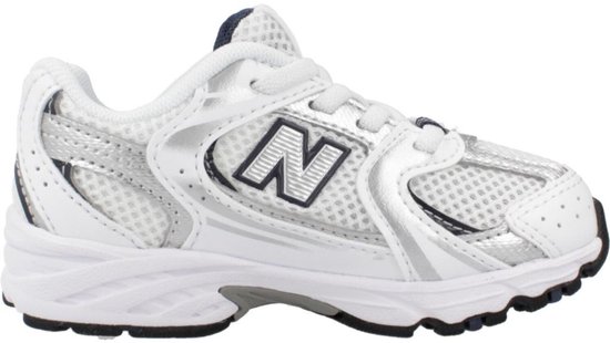 Witte New Balance 530 sneakers met zilverkleurige en marineblauwe accenten.