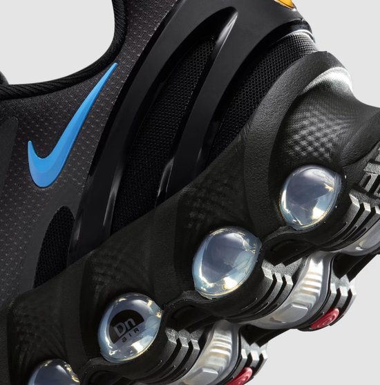 Close-up van de zwarte Nike Air Max Dn herenschoen, met blauwe Nike swoosh en Air Max demping.