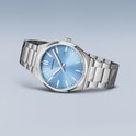 Zilverkleurig herenhorloge met blauwe wijzerplaat. De wijzerplaat heeft een datumweergave. Het horloge heeft een metalen band.