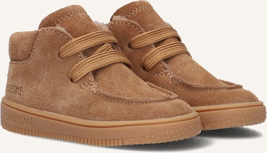 Close-up van twee bruine suède mid-top sneakers met veters. 'SHOESME' is zichtbaar op de zijkant en zool.