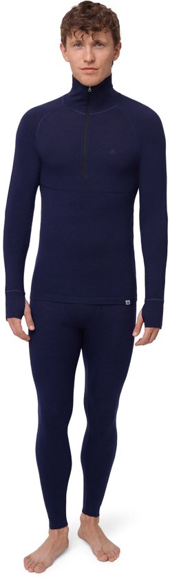 Model in een marineblauwe thermoshirt met rits en bijpassende thermobroek.
