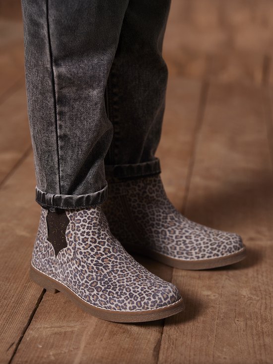 Leren laarsjes met luipaardprint gedragen onder een grijze jeans.