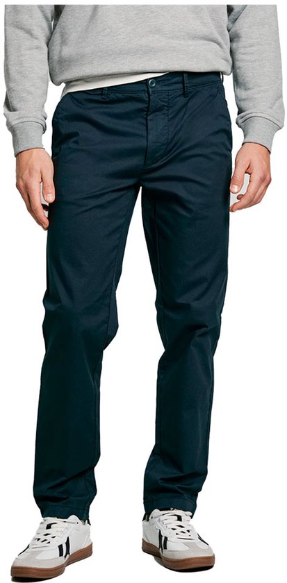 Donkerblauwe katoenen chino gedragen met grijze trui en sneakers.