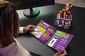 Personne lisant un livret LEGO Fortnite avec une offre pour une tenue en jeu et un restaurant construit