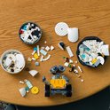 Set de construction LEGO WALL-E avec des pièces et WALL-E sur une table en bois.