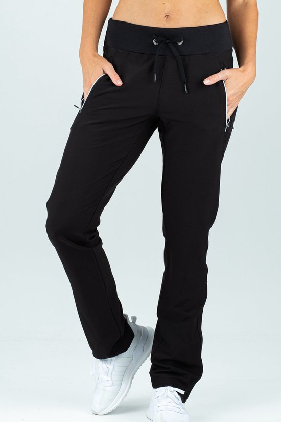 Zwarte stretch trainingsbroek voor dames met ritszakken, gedragen met witte sportschoenen.