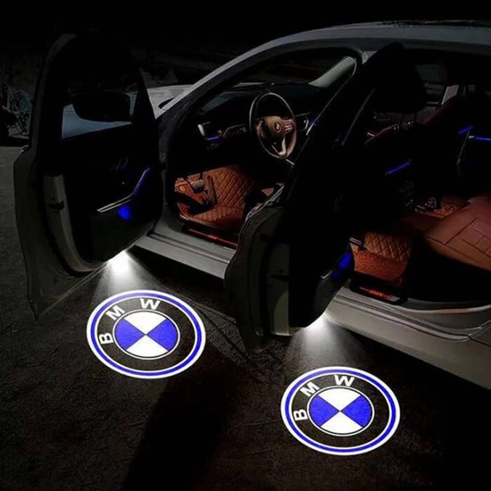 Twee BMW logo's geprojecteerd op de grond naast geopende autodeuren, met sfeerverlichting.
