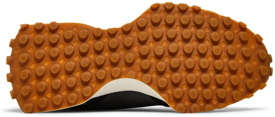 Onderkant van een zwarte New Balance sneaker met een bruine, noppen-achtige profielzool.