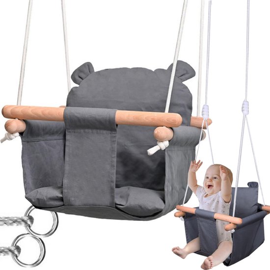 Grijze babyschommel met houten leuningen en beren-oren, met lachende baby.