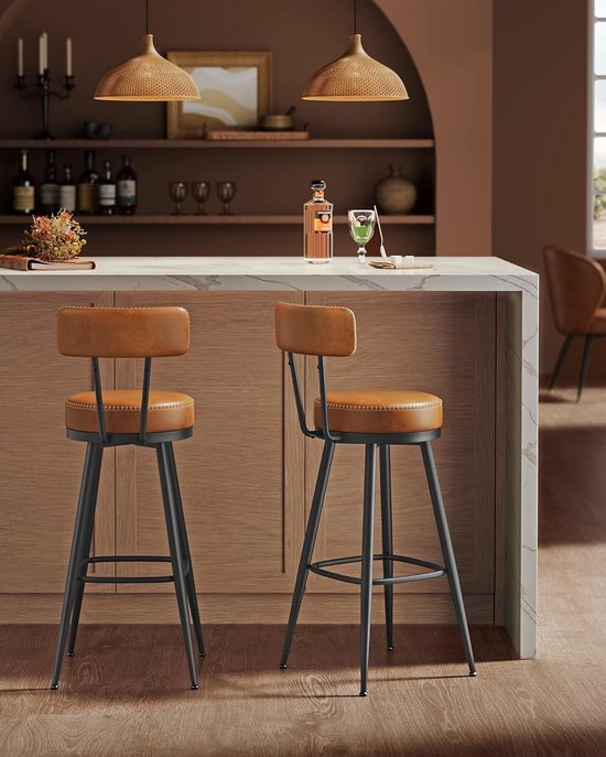Deux tabourets de bar marron caramel avec dossiers près d'un comptoir de cuisine moderne.