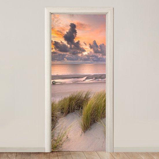 Deurposter met duinlandschap bij zonsondergang boven de zee.