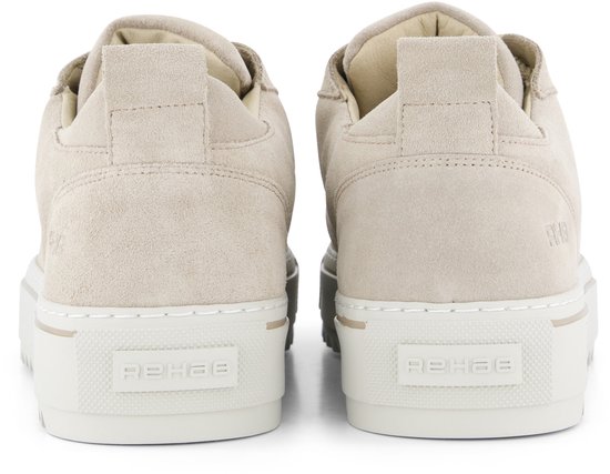 Achterkant van twee crème suède lage sneakers met beige veters en logo op de zool.