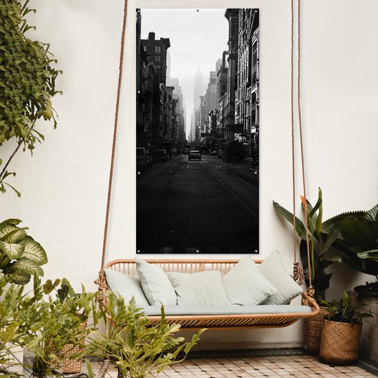 Affiche de clôture Une voiture roule dans une rue calme de New York en noir et blanc - 100x200 cm - Toile jardin
