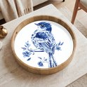 Rond houten dienblad met Delfts blauw vogeldecor op een marmeren tafel.