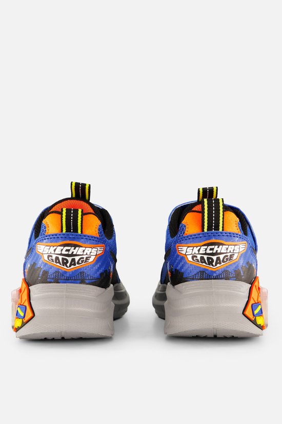 Achterkant van blauwe Skechers sneakers met oranje en zwarte "Skechers Garage" print van een stad.