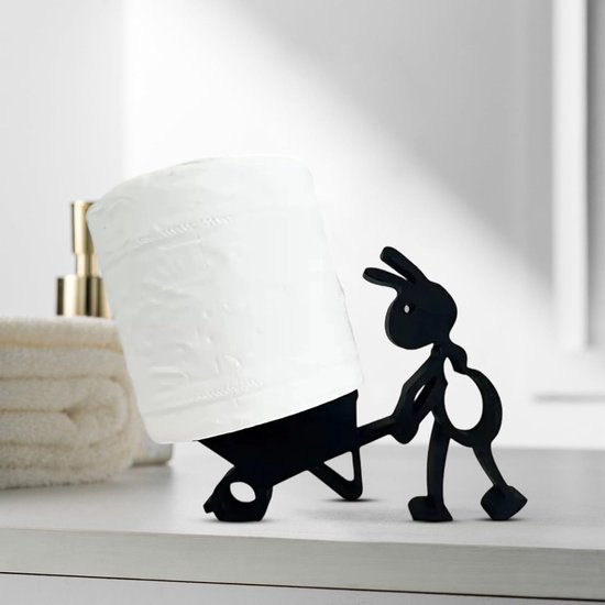 Zwarte metalen toiletrolhouder in de vorm van een mier die een rol papier duwt in een kruiwagen.