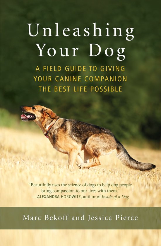 Boek 'Unleashing Your Dog' met een veld gids voor honden, met een hond op de voorgrond.