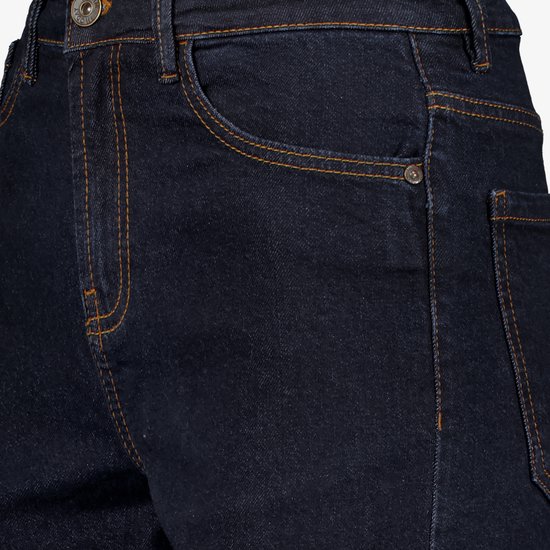 Detail van donkerblauwe jeans met oranje stiksels, zakken en knoopsluiting.