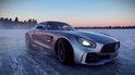Zilverkleurige Mercedes-AMG GT racewagen op een besneeuwd oppervlak.