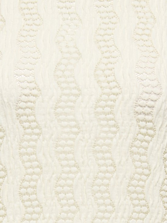 Crème textiel met golvende verticale patronen en open gewerkte details.