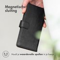 Étui portefeuille noir à fermeture magnétique, tenu par une main.