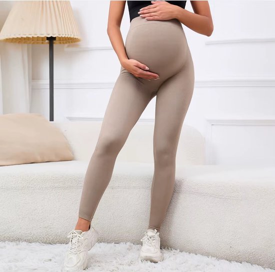 Zijzicht van donkerbeige naadloze zwangerschapslegging met textuur en hoge taille, gedragen door een zwangere vrouw.
