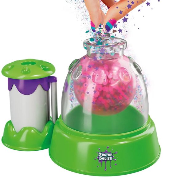 Doctor Squish Squishy Maker machine met een potje, groene basis en paarse dop. Glitter wordt toegevoegd.