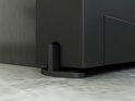 Un guide de sol noir en forme de L pour une porte coulissante.