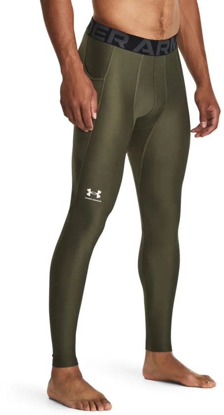 Model draagt een olijfgroene Under Armour sportlegging met witte logo-opdruk op het been.