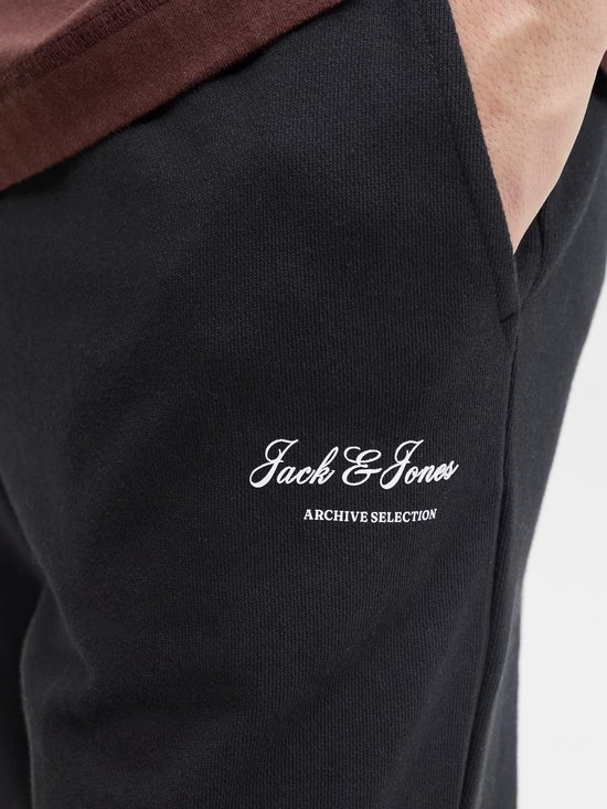 Zwarte joggingbroek met witte 'Jack & Jones ARCHIVE SELECTION' opdruk op de linkerheup.