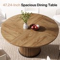 Ronde houten eettafel met visgraatpatroon en plant in vaas.