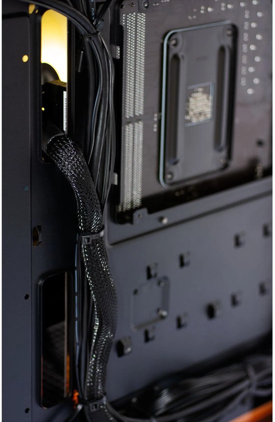 Zwarte kabels, netjes weggewerkt met tie-wraps, langs de binnenkant van een computerbehuizing.