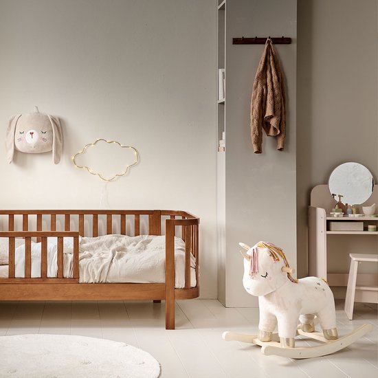 Kinderkamer met houten bed, roze kaptafel met spiegel en speelgoed eenhoorn.