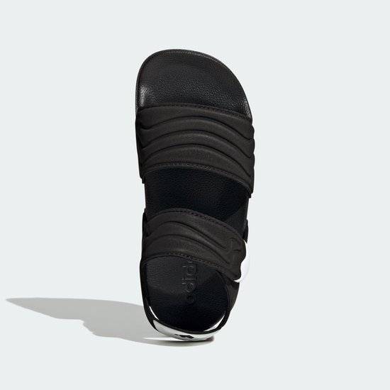 Zwarte Adidas Adilette kindersandalen met golvend patroon op de bandjes.