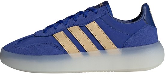 Blauwe Adidas sneaker met beige strepen, van de zijkant gezien.