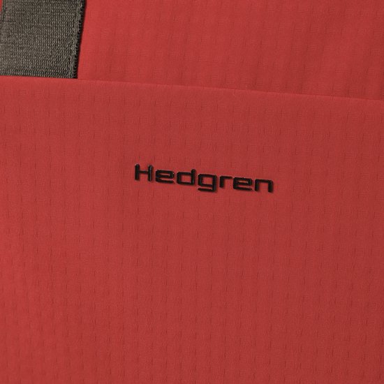 Detail van het zwarte Hedgren logo op de rode rugzak.