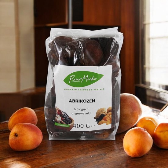 Puur Mieke biologische abrikozen ongezwaveld 400g met verse abrikozen ernaast.