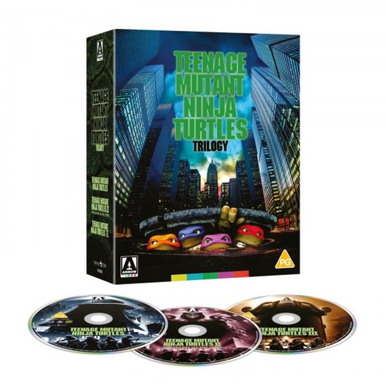 Teenage Mutant Ninja Turtles Trilogy boxset met de vier schildpadden die uit het water kijken, met stadsachtergrond. Drie Blu-ray discs op de voorgrond.