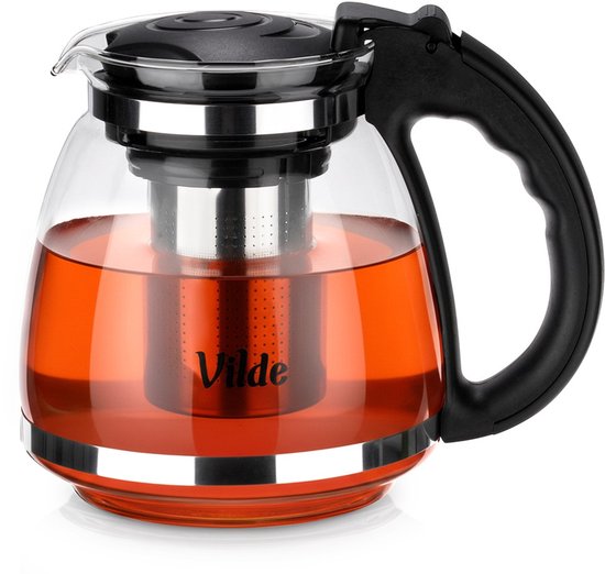 Glazen theepot gevuld met oranje thee, met roestvrijstalen infuser, zwarte deksel en handvat, en zilveren accenten.