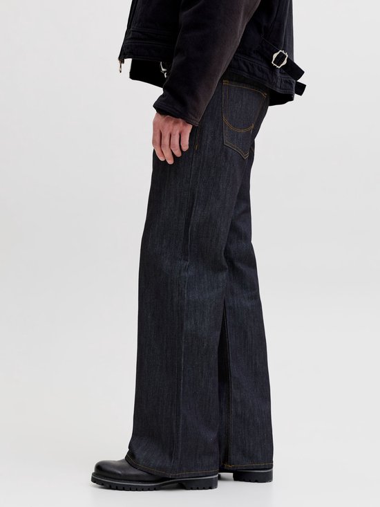 Zij-aanzicht van de broekspijpen van een donkere jeans met wijd uitlopende pasvorm.