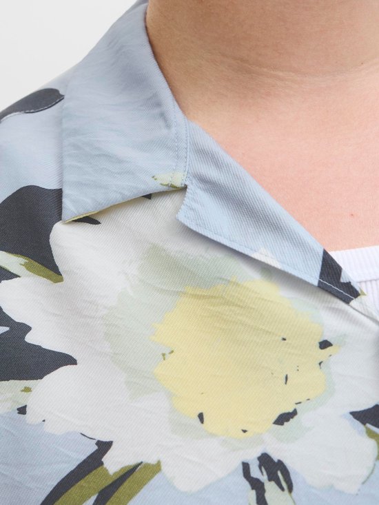 Kraag van lichtblauwe stof met grote witte en gele bloemenprint.