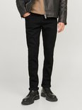 Man met zwarte jeans en een bruin T-shirt.