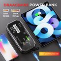 Zwarte jumpstarter laadt een iPhone en iPad op via USB-C en USB-A poorten.